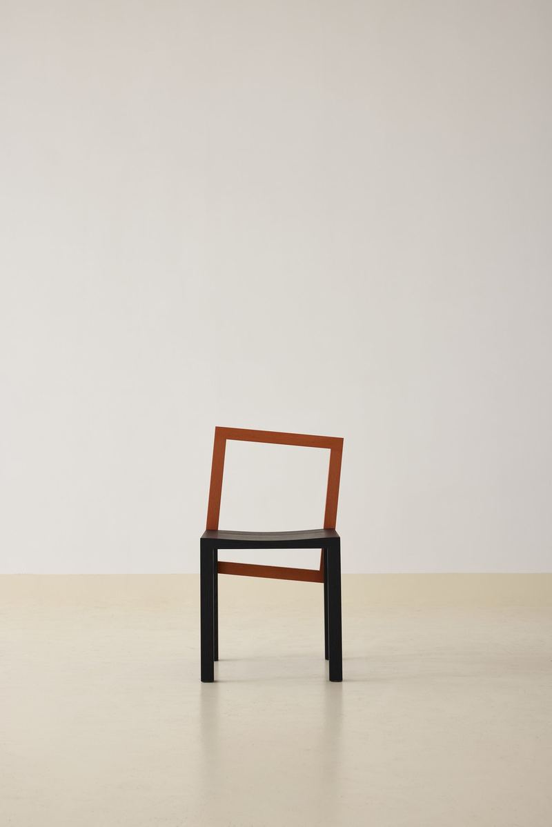 Block Chair in black with an orange-red back accent